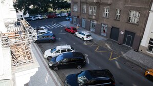 A street view with parked cars and a building with multiple windows and doors. - 2 Bed Flat - Sleeps 9 - Pets - Smoking on terrace (Praha)