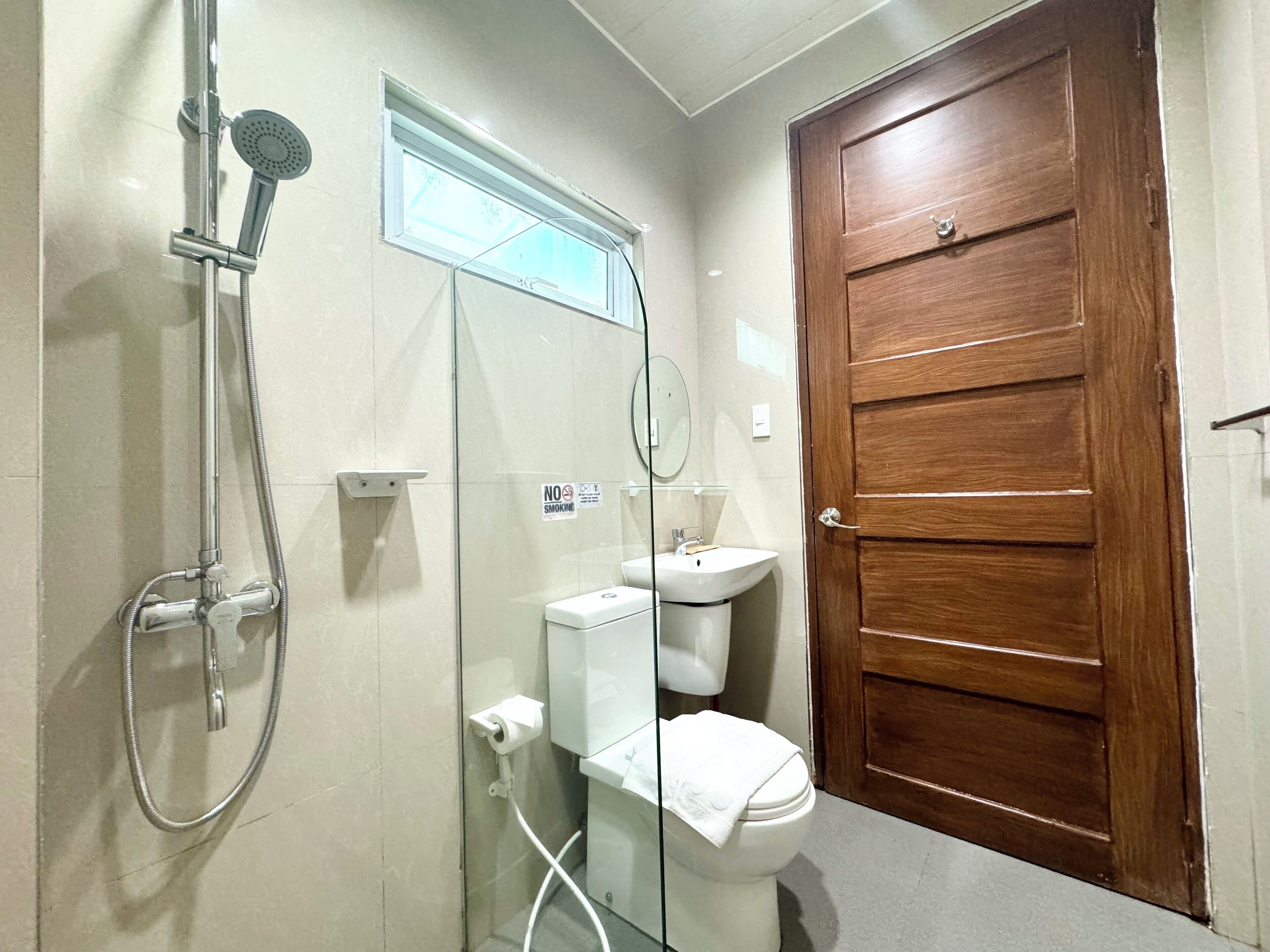 Une salle de bain avec douche, toilettes et lavabo.