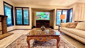 Ein Wohnzimmer mit Kamin, Fernseher und einer Couch.