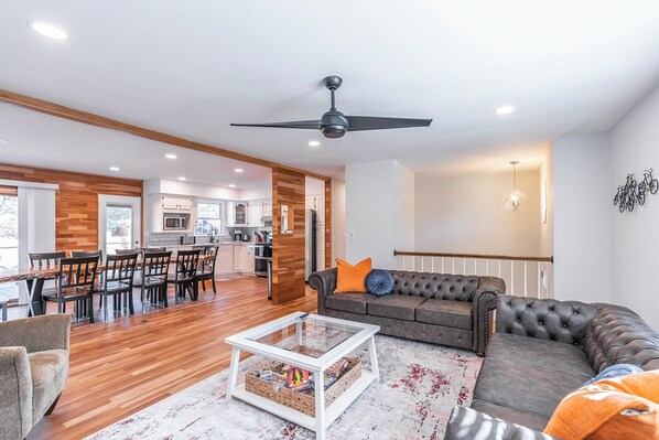 A spacious living area with a modern kitchen, a dining area, and a seating area with a sofa and coffee table.