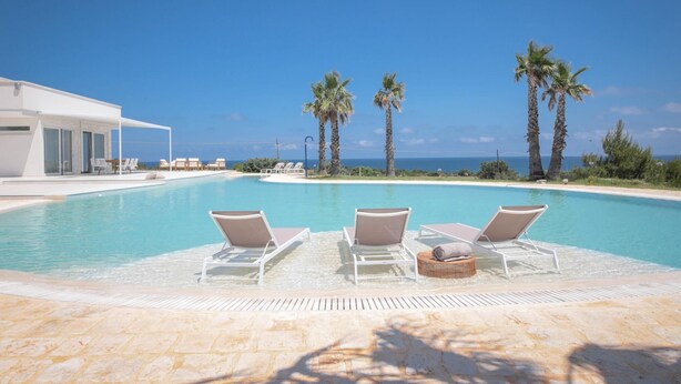 A poolside area with lounge chairs and a view of the ocean. - TD Villa Maestrale Luxury Pool Sea View (Monopoli)