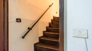 A staircase with wooden steps and a metal handrail, leading to an upper floor. - Via Duomo 196 in Naples (Naples)
