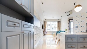 A modern kitchen with grey cabinets, a marble island, and pendant lighting. - Tresor 3 bedrooms with pool gym in center (Thành phố Hồ Chí Minh)