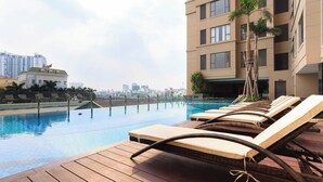 A rooftop pool area with lounge chairs and a view of the city skyline. - Tresor 3 bedrooms with pool gym in center (Thành phố Hồ Chí Minh)