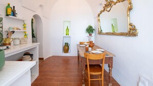 A dining area with a wooden table, chairs, and a large ornate mirror on the wall. - Biancostuni 44, The Little White Houses (Ostuni)