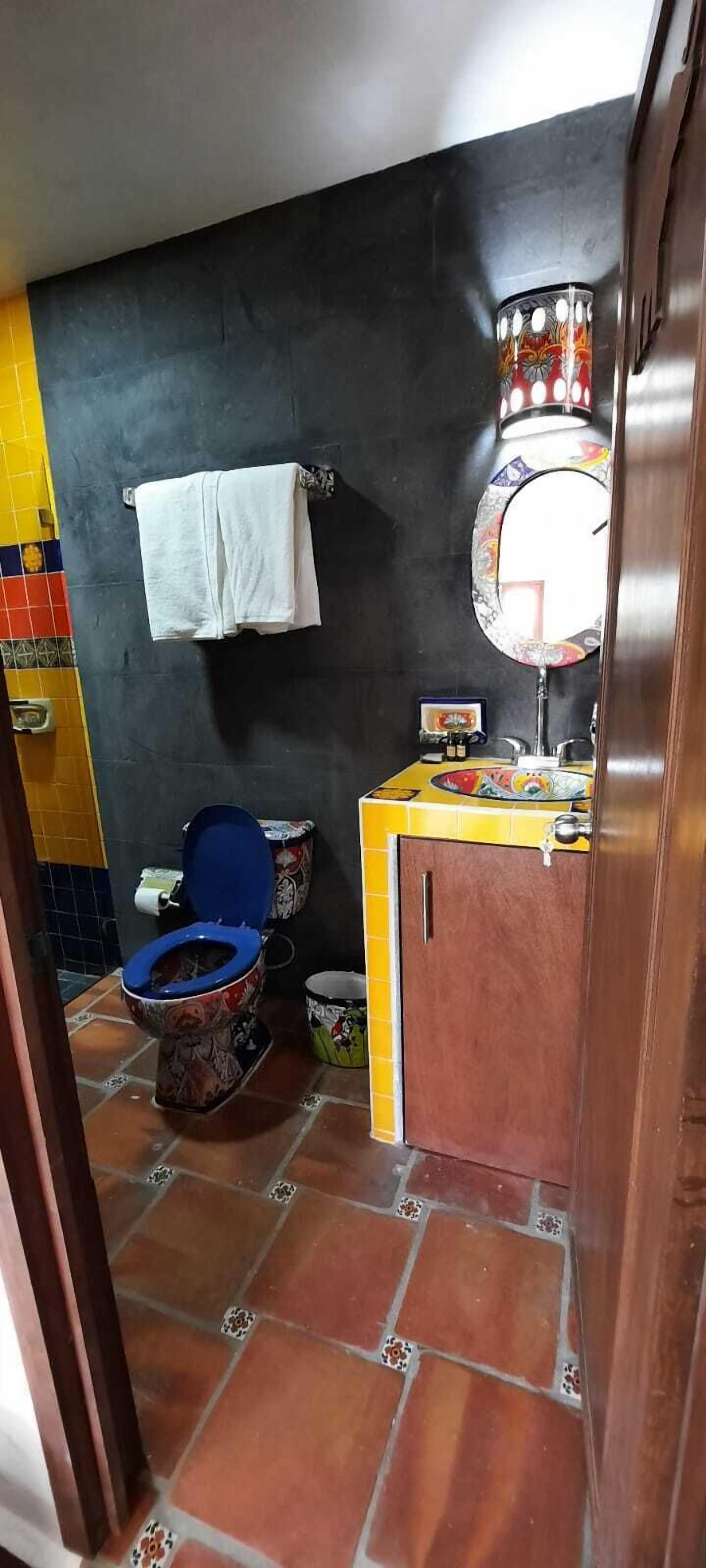 Une salle de bain avec des toilettes, un lavabo et un miroir.