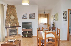 Cozy living room with a fireplace, flat-screen TV, and dining area.