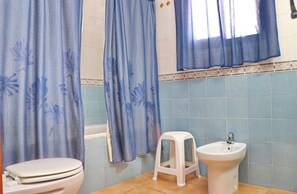 Bathroom features a white toilet, pedestal sink, and bathtub with a shower curtain.