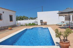 Relax by the pool surrounded by lush greenery and a serene atmosphere.