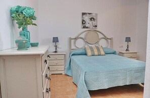 Cozy retreat with a centered bed, bedside tables, and a decorative vase on a dresser.