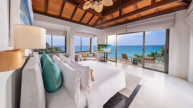 A spacious bedroom with a large bed, a TV, and a view of the ocean. - Villa La Prana (Kamala)