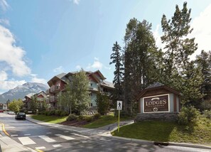 A row of multi-story buildings with a sign for The Lodges at Canmore Pool. - Spacious King Bed with Pool & Hot Tubs (Canmore)