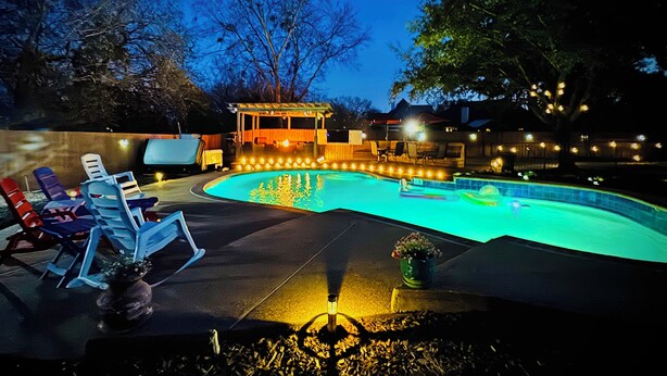 A swimming pool with a sunken hot tub, lounge chairs, and a covered seating area. - Backyard Oasis with Private Pool, SPA and Putting Green only 2 Miles from TAMU! (College Station)