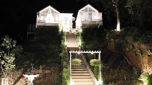 A two-story building with a staircase leading to the entrance, surrounded by greenery. - La Maison Blanche B&B with Romantic Outdoor Bath & Panorama View (Chiang Rai)