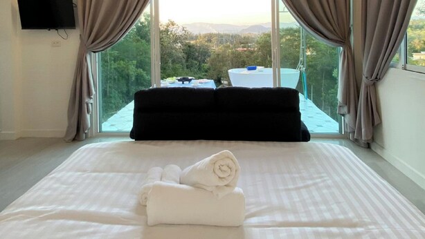 A bedroom with a large bed, a chandelier, and a view of the outdoors. - La Maison Blanche B&B with Romantic Outdoor Bath & Panorama View (Chiang Rai)