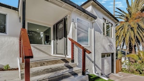 A two-story house with a front porch, a garage, and a palm tree in the yard. - 246A- Modern 3B2B w/ Deck & View by Hillsdale Mall (San Mateo)