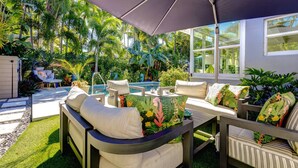 An outdoor patio with a pool, surrounded by lush greenery and tropical plants. - Vahevala: Your Tranquil Mid-Town Key West Oasis, 3BR Home, Pool & Close to Beaches & Duval Street! (Key West)