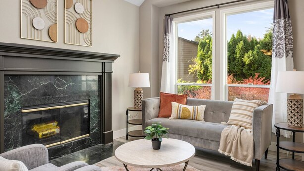 A modern living room with a fireplace, grey sofa, and a round coffee table. - Exceptional Pet Friendly Home, Game Room w/ Pool Table, Large Deck and Seating, 5 Miles to Portland (Portland)