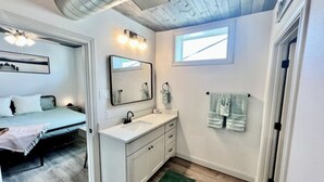 Ein Schlafzimmer mit einem Bett, einem weißen Schminktisch mit Spiegel und einem grünen Teppich.