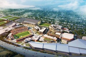 An aerial view of a sports stadium complex with multiple buildings, a large stadium, and surrounding green spaces. - Larger 2 Bedroom Apt in the Heart of Canton, Minutes From HOF and Both Hospitals (Canton)