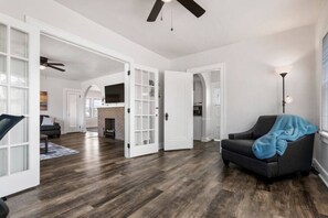 A spacious living area with hardwood flooring, a fireplace, and a modern kitchen in the background. - Larger 2 Bedroom Apt in the Heart of Canton, Minutes From HOF and Both Hospitals (Canton)