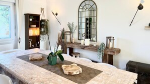 Una sala de estar moderna con un ventanal grande, chimenea y comedor.