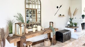 Una sala acogedora con un banco de madera, un espejo grande y una chimenea.