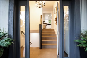 A modern interior with a staircase leading to a kitchen area. - Lakeside home on Horseshoe Lake: kayaks, paddle boards, fire pit, games, fishing (Port Orchard)