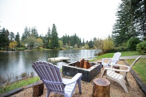 A lakeside seating area with Adirondack chairs and a fire pit. - Lakeside home on Horseshoe Lake: kayaks, paddle boards, fire pit, games, fishing (Port Orchard)