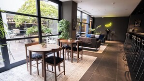 Un interior moderno con ventanas amplias, muebles de madera y plantas en macetas.