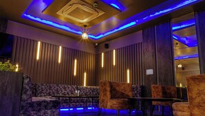 A modern lounge area with a sofa, armchairs, and a small table. - HOTEL JAI HARSH BY DIVYANSHI HOSPITALITY (Jaipur)