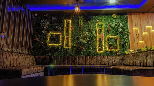 A cozy lounge area with a green wall, wooden paneling, and a seating arrangement. - HOTEL JAI HARSH BY DIVYANSHI HOSPITALITY (Jaipur)