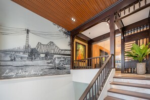 A staircase with wooden railings and a mural depicting a bridge and people. - Le Parfum Apartment And Hotel (Hanoi)