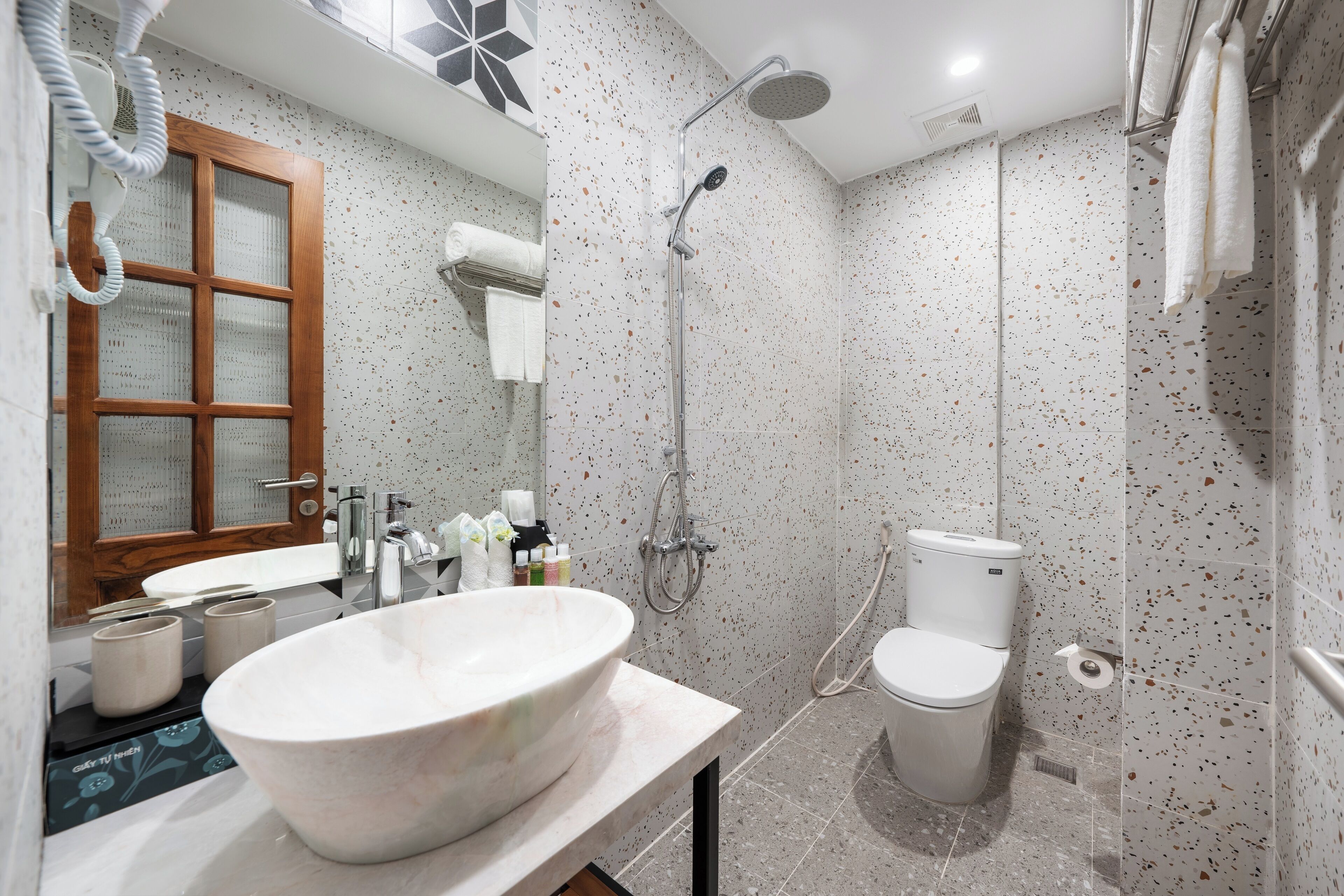 Une salle de bain moderne avec un lavabo sur pied, une douche et des toilettes.