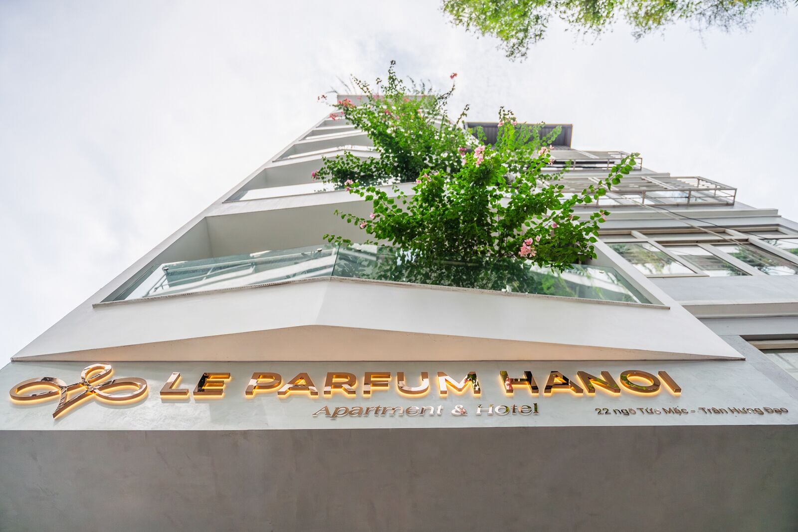 A modern building with a sign reading "Le Parfum Hanoi Apartments & Hotel".