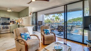 A spacious living area with a balcony, a kitchen, and a dining area.
