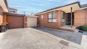 A residential property with a garage, a covered porch, and a brick exterior. - Highett Charm - 3 bedroom Unit (Highett)