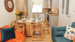 A compact living space with a dining area, kitchenette, and a sofa. - 4 Martindales Yard (Kendal)