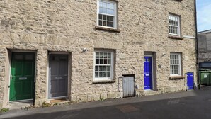 A stone building with multiple doors and windows, including a green and a blue door. - 4 Martindales Yard (Kendal)