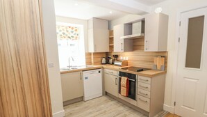A modern kitchen with a dishwasher, oven, and a built-in stove. - 4 Martindales Yard (Kendal)