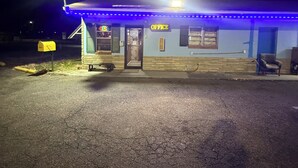 A small building with a sign reading "OFFICE" at night, illuminated by streetlights.