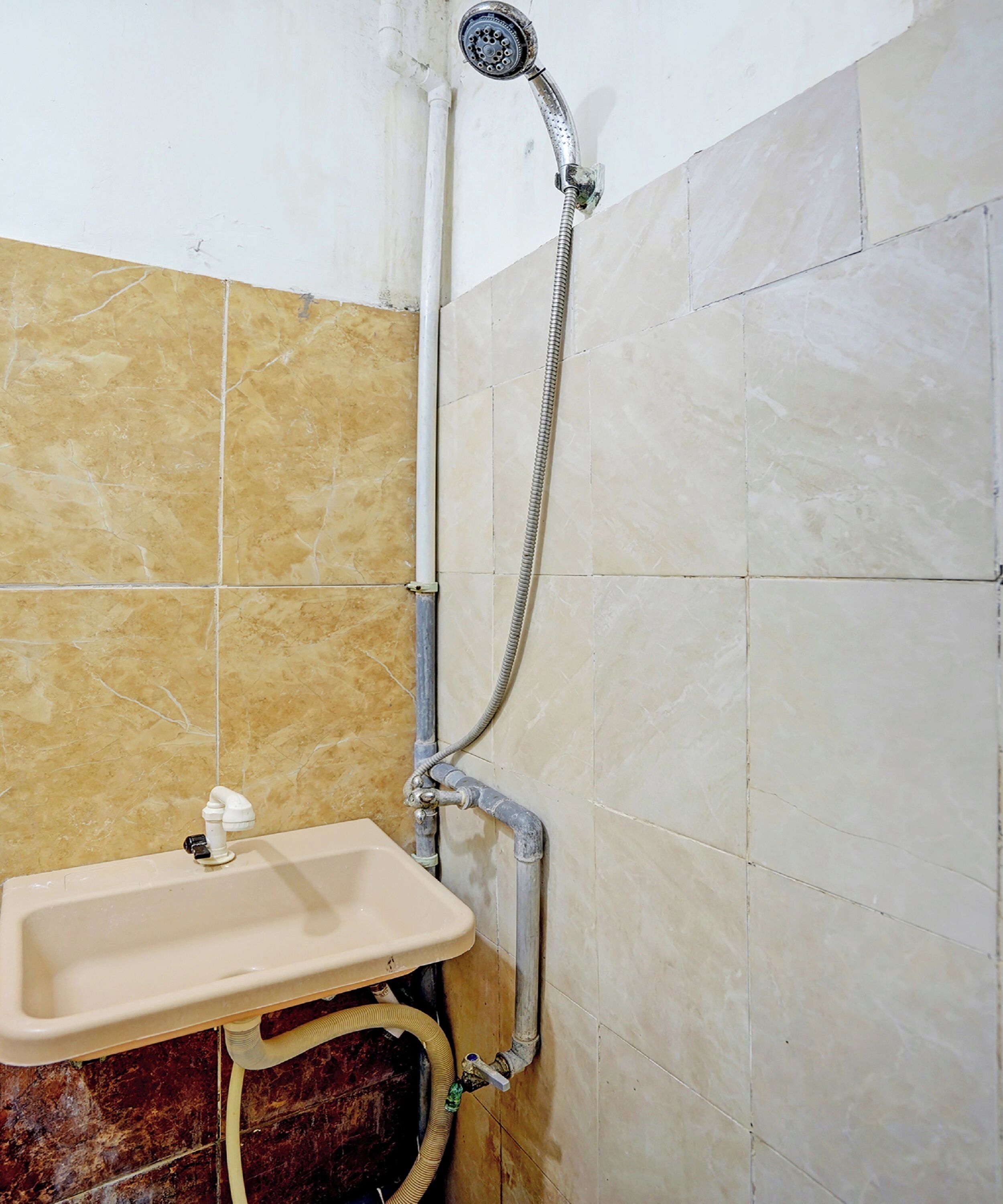 A bathroom with a shower, sink, and tiled walls.