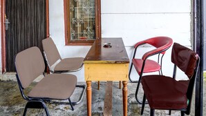 Un pequeño espacio al aire libre con mesa de madera y cuatro sillas.