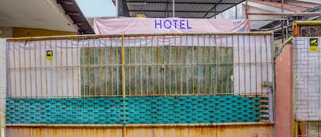 A hotel with a metal gate, a sign reading "HOTEL", and a tiled roof.