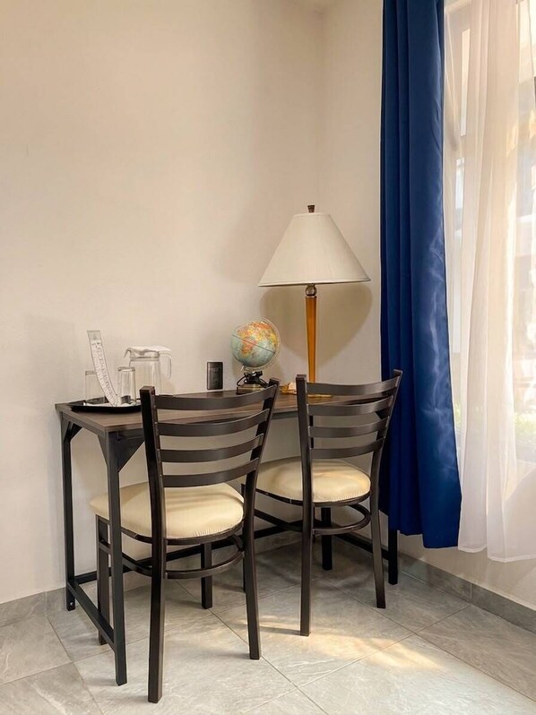 A small dining area with a table, chairs, a globe, a lamp, and a window with curtains. - La Palma Co-living (Tecamac)