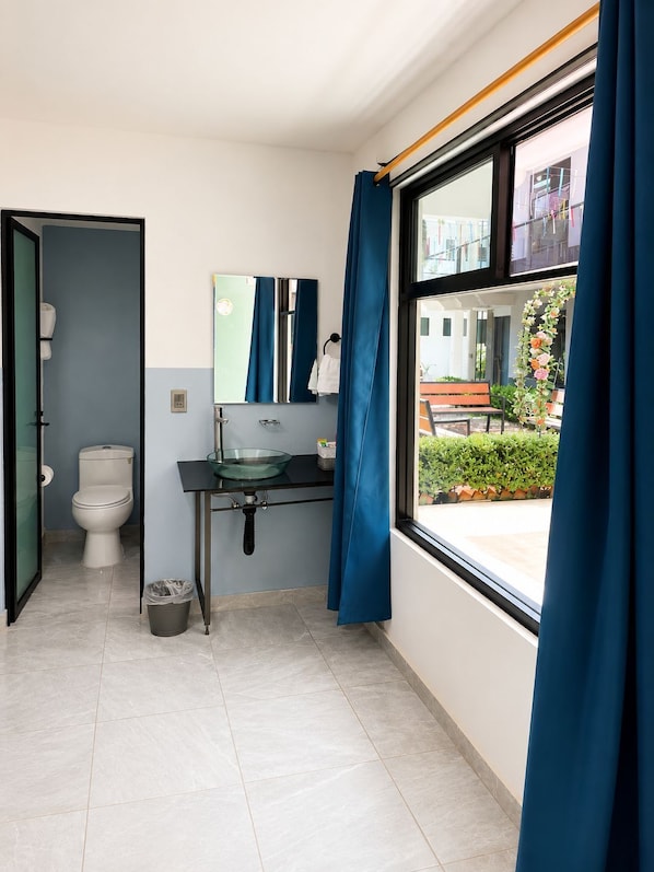 Un baño moderno con inodoro, lavamanos y espejo.