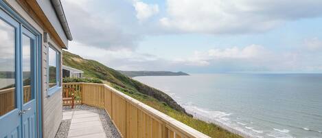 A coastal property with a wooden deck and a view of the sea.