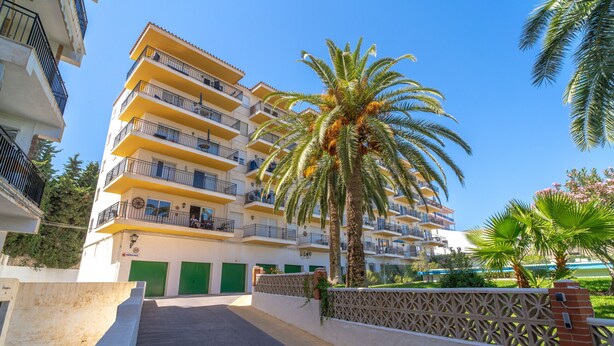 A multi-story hotel with balconies, a palm tree, and a gated entrance. - Acapulco Apartment 7 by Casasol (Nerja)