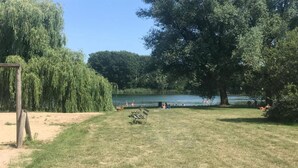 A park with a lake, benches, and trees.