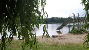 A lakeside view with a wooden dock and a metal staircase leading into the water.